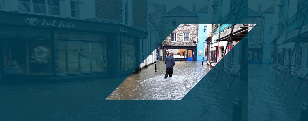 man walking in flooded town centre