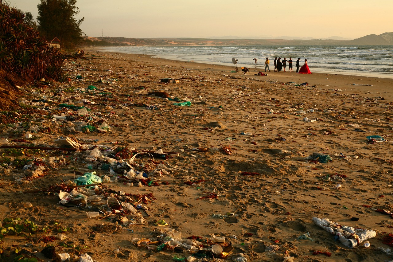 a beach at sunset scattered with plastic and rubbish